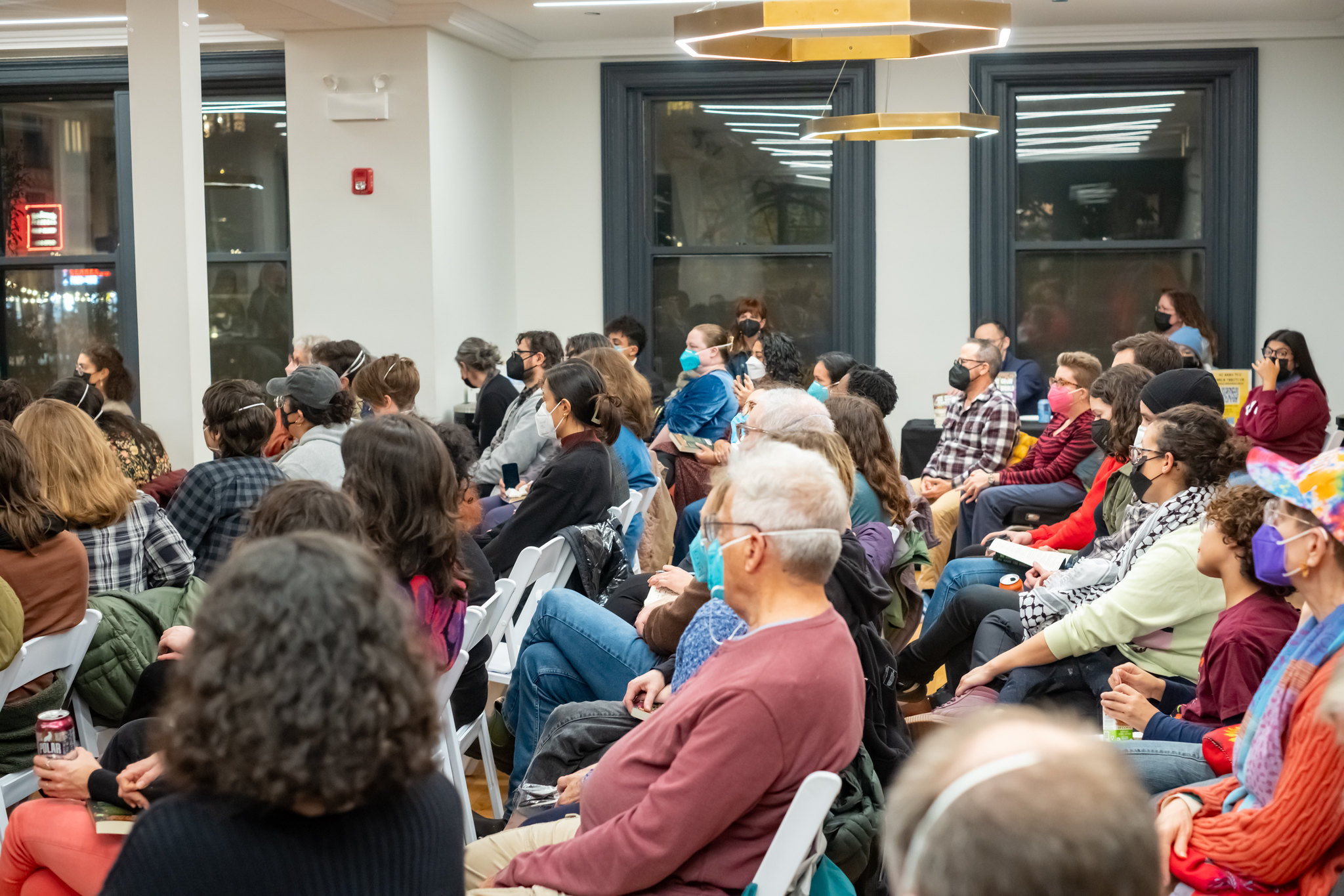 A large audience listens to a speaker at a Haymarket House event.