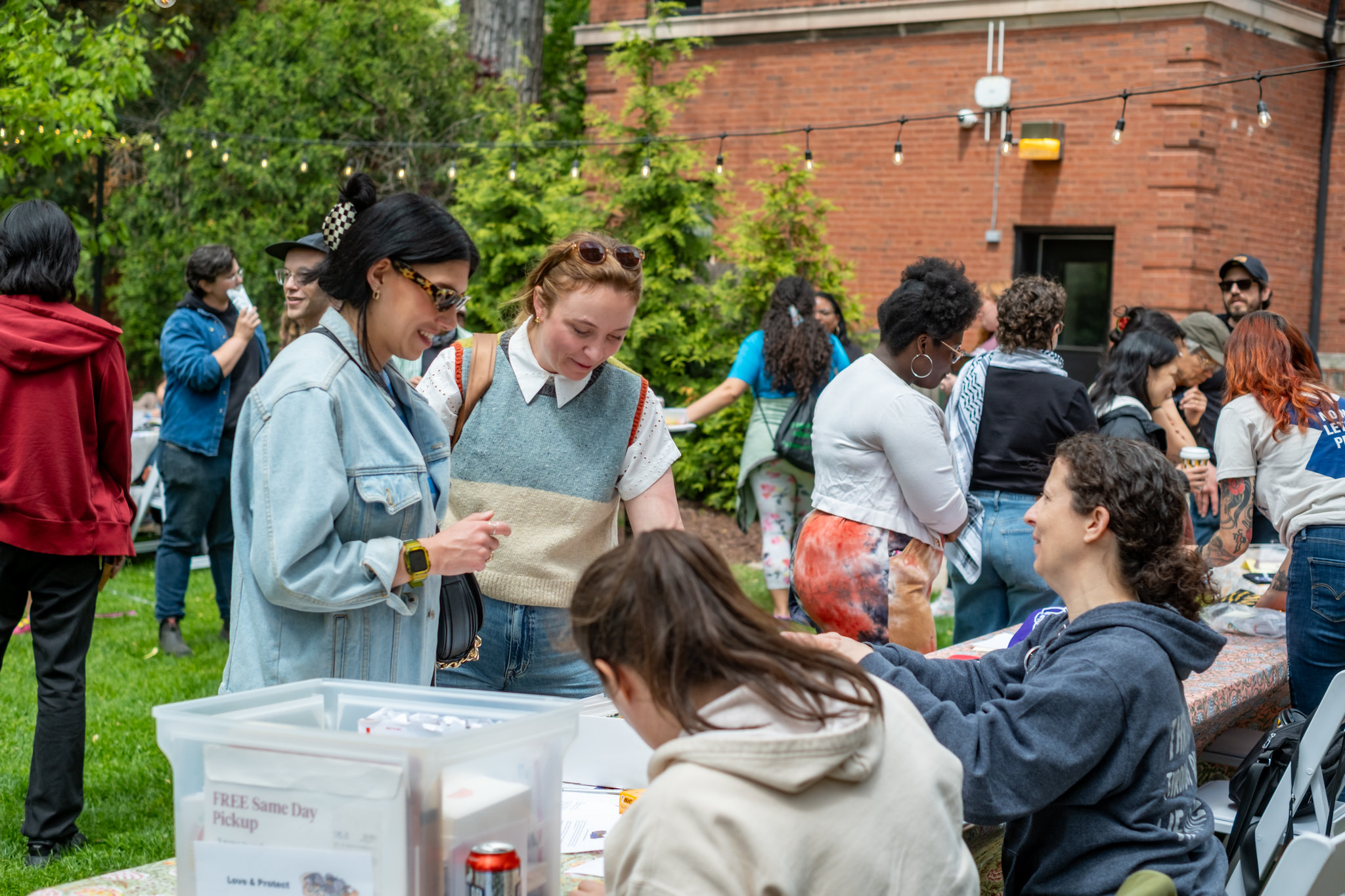 A large group of diverse people attend an outdoor Haymarket House event.
