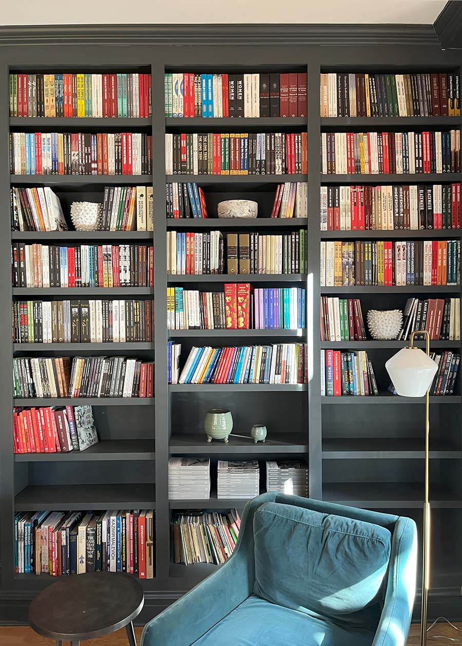 Three large floor to ceiling bookshelves fully filled with books.